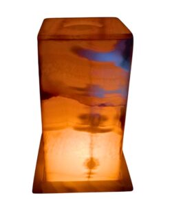 Square alabaster lamp glowing softly in a dimly lit room