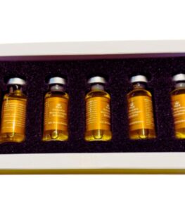 Woman applying gold collagen serum on face